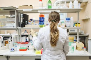 Scientist works in lab practicing pharmacovigilance; pharmaceuticals