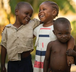 Three African children smiling, philanthropy